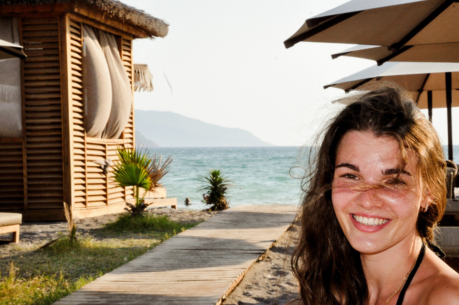 Smiling woman on the beach boardwalk in golden sun